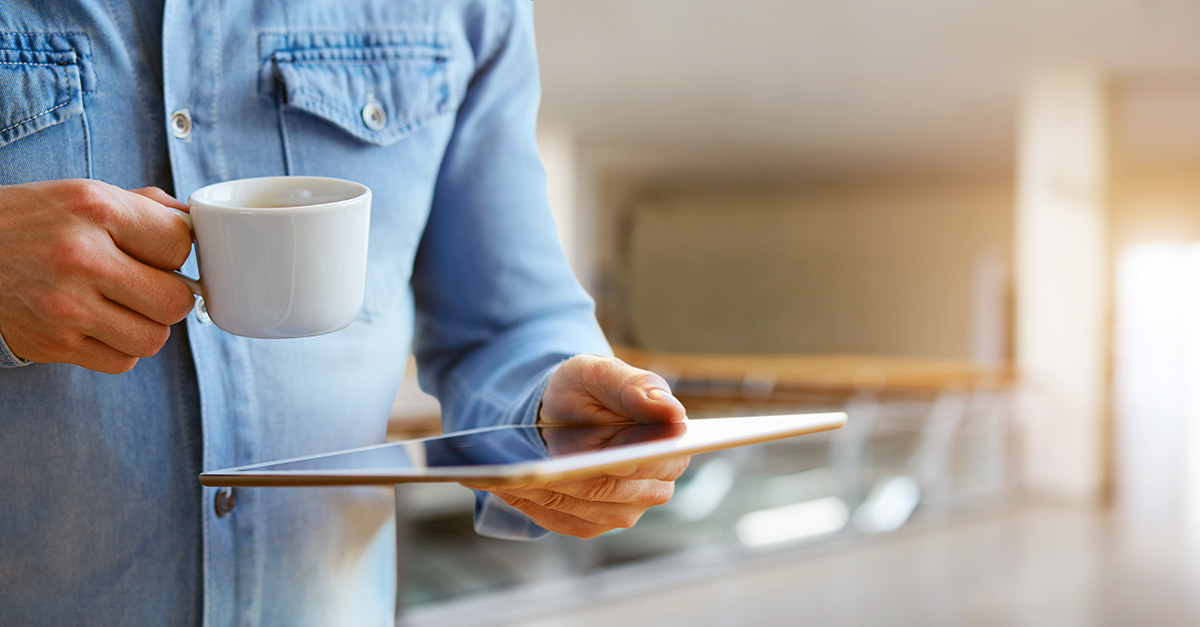 Guy drinking coffee looking at ipad