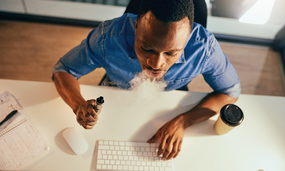 Guy vaping at computer